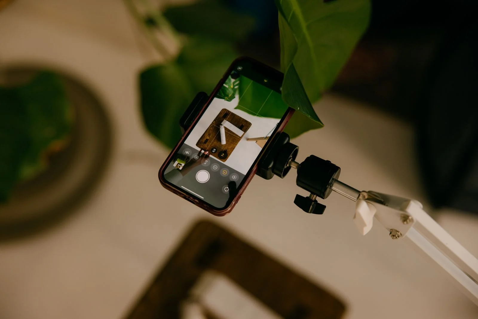Telefon statiivil pildistamas lauale sätitud seadet